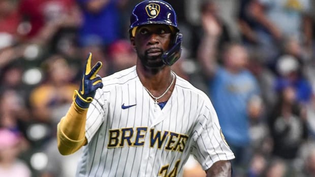 Andrew McCutchen holds up two fingers while running to first base in a game with the Brewers.